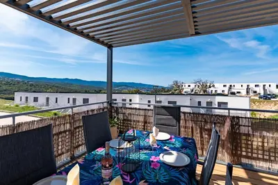 a patio with a table and chairs on a balcony at Nepita in Porticcio
