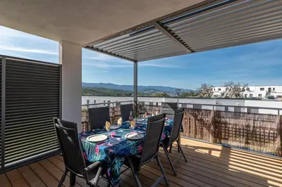 a dining room with a table and chairs on a balcony at Nepita in Porticcio