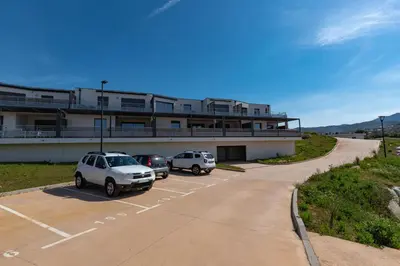 a parking lot with cars parked in front of a building at Nepita in Porticcio