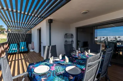 a dining room with a table and chairs on a deck at Nepita in Porticcio