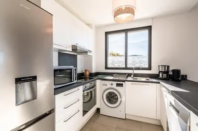 a kitchen with a washer and dryer and a window at Nepita in Porticcio