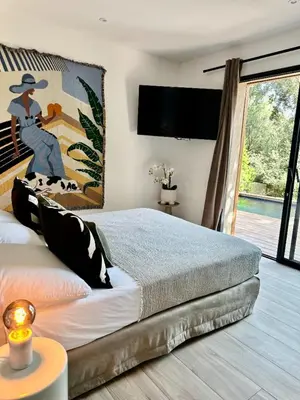 a bedroom with a bed with a painting on the wall at Les Bergeries de Figari in Figari