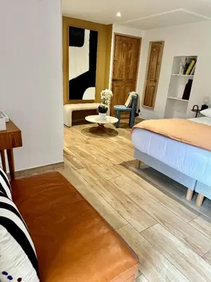 a bedroom with a bed and a chair and a table at Les Bergeries de Figari in Figari