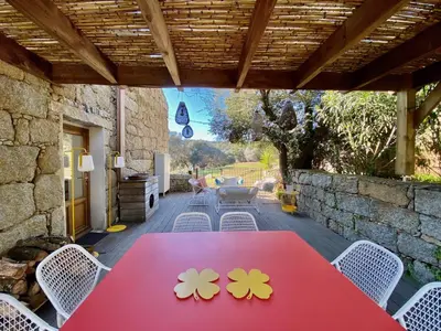 a red table with flowers on it on a patio at Les Bergeries de Figari in Figari