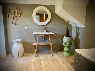 a bathroom with a mirror and a table and a vase at Les Bergeries de Figari in Figari