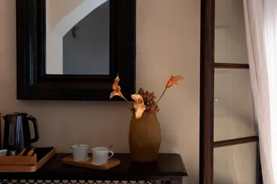 a vase with flowers in it on a table at Hôtel Case Latine in Lama