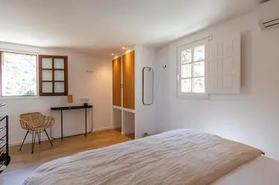 a bedroom with a bed and a table and windows at Hôtel Case Latine in Lama