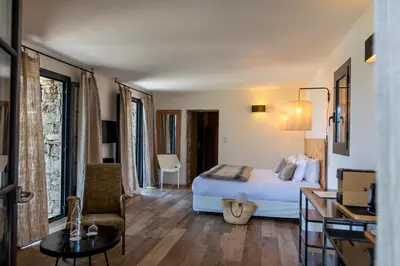 a hotel room with a bed and a table at Hôtel Case Latine in Lama