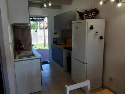 a kitchen with a white refrigerator and a sink at Villa, maison bord de mer climatisée in Poggio-Mezzana