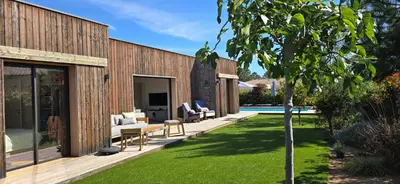 a house with a yard with chairs and a tree at Casa di Leccia, Superbe Villa à proximité immédiate des plages, piscine privée in Lecci