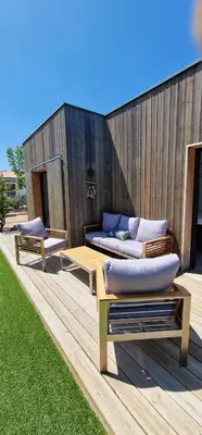a deck with two beds and benches on it at Casa di Leccia, Superbe Villa à proximité immédiate des plages, piscine privée in Lecci