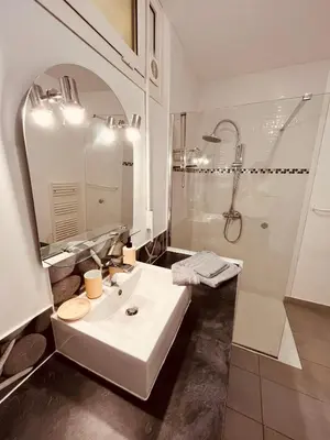 a white bathroom with a sink and a shower at Superbe T2 avec place de parking in Ajaccio