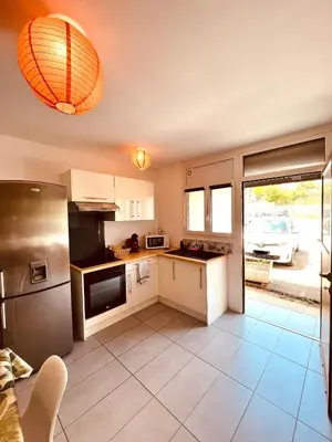 a kitchen with a refrigerator and a car parked outside at Superbe T2 avec place de parking in Ajaccio
