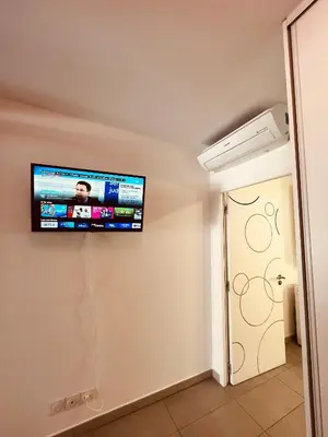 a flat screen tv on the wall of a room at Superbe T2 avec place de parking in Ajaccio