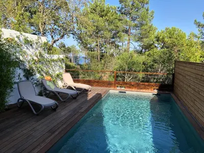 a swimming pool with two chairs on a wooden deck at Corsica Townhouse near Canella Beach in Favone