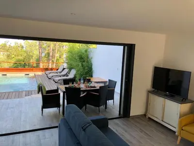a living room with a table and chairs and a television at Corsica Townhouse near Canella Beach in Favone