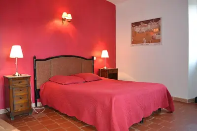 a red bedroom with a bed and two night stands at a Casa in Calenzana