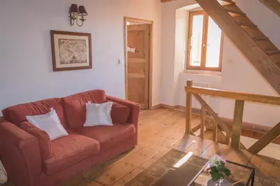 a living room with a red couch and a glass table at a Casa in Calenzana