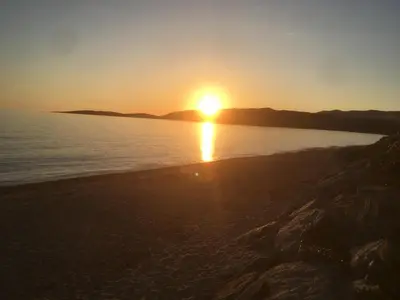 a sunset on a beach near the water at La Rose Bleue (1) in Olmeto