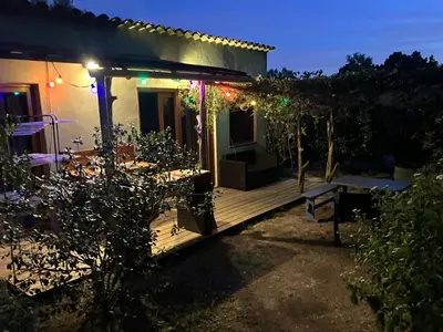 a house with a deck at night with lights at La Rose Bleue (1) in Olmeto