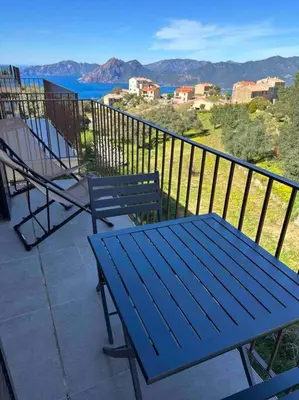 a blue picnic table and chairs on a balcony with a view at Appartement de standing piana in Piana