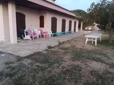 a group of chairs and tables outside of a building at GRANDE VILLA TIZZANO A 200 M DE LA PLAGE 18 PERS in Sartène