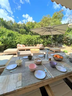 a wooden table with bowls and plates on it at Villa A Muredda in Sainte-Lucie de Porto-Vecchio