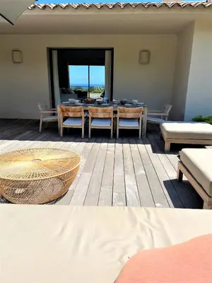 a patio with a table and chairs and a view of the ocean at Villa A Muredda in Sainte-Lucie de Porto-Vecchio