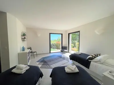 a white room with two beds and a window at Villa A Muredda in Sainte-Lucie de Porto-Vecchio