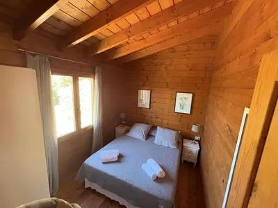 a bedroom with a bed in a wooden cabin at Chalet Maria in Bonifacio