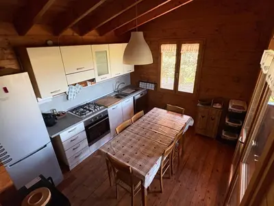 a kitchen with a wooden table in a cabin at Chalet Maria in Bonifacio