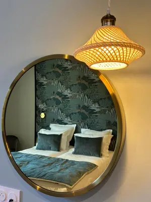 a mirror on a wall with a bed and pillows at Grand Hôtel de la Scala in Calacuccia