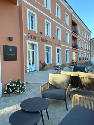 a patio with chairs and tables in front of a building at Grand Hôtel de la Scala in Calacuccia