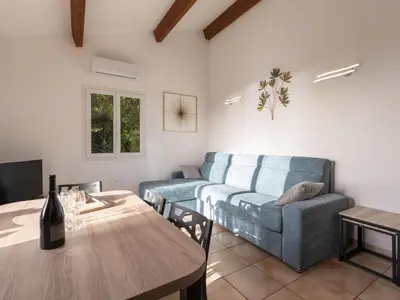 a living room with a couch and a table at Holiday Home Villa Bruzzi by Interhome in Pianottoli-Caldarello