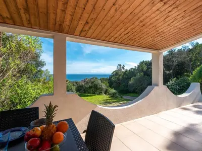 a table with a bowl of fruit on a patio at Holiday Home Villa Bruzzi by Interhome in Pianottoli-Caldarello