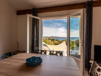 a room with a table with a view of the ocean at Holiday Home Villa Bruzzi by Interhome in Pianottoli-Caldarello
