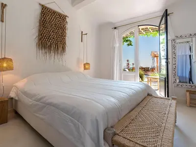 a white bedroom with a large bed and a window at Villa Villa Casaben by Interhome in Porto-Vecchio