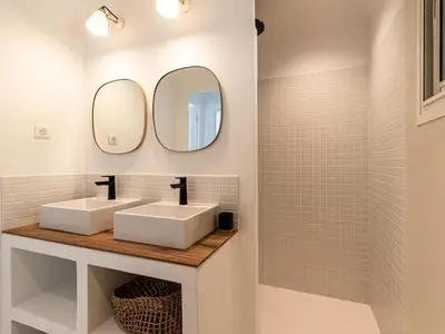 a bathroom with two sinks and two mirrors at Villa Villa Casaben by Interhome in Porto-Vecchio