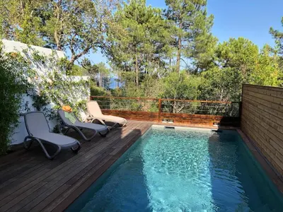 a swimming pool on a deck with two chairs next to it at Les Jardins d'Eve, Solenzara, townhouse with private pool in Favone