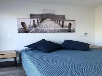 a bedroom with a bed and a painting on the wall at Les Jardins d'Eve, Solenzara, townhouse with private pool in Favone