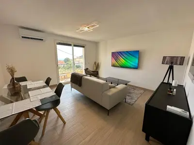a living room with a couch and a table at Alivu - Appartement Moderne Avec Terrasse in Cargèse