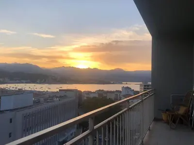 a view of a city at sunset from a building at Très bel appartement avec terrasse de 87m2 avec une superbe vue panoramique sur la baie d Ajaccio in Ajaccio