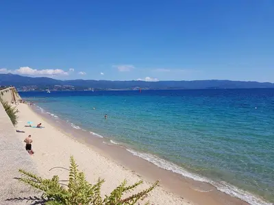 a wall on a beach with a body of water at Très bel appartement avec terrasse de 87m2 avec une superbe vue panoramique sur la baie d Ajaccio in Ajaccio