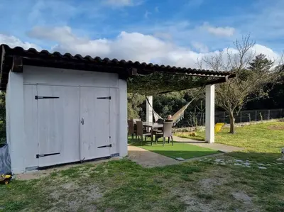 a white shed in a yard with a table at appartement en rez de jardin in Foce