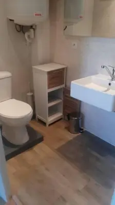 a bathroom with a white toilet and a sink at appartement en rez de jardin in Foce