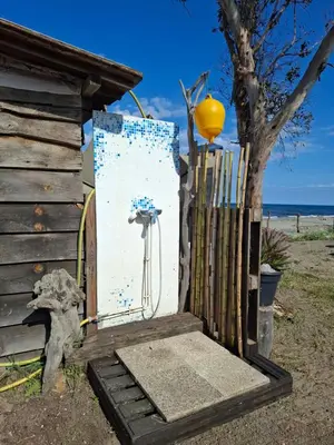a door to a house with a fence and a tree at Caravane janis on the beach in Lucciana