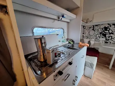 a small kitchen with a stove and a sink at Caravane janis on the beach in Lucciana