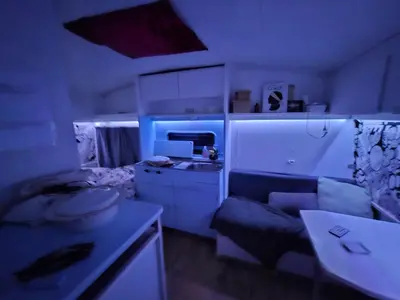 a room with a kitchen and a couch in a room at Caravane janis on the beach in Lucciana