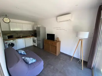 a living room with a couch and a kitchen at Mini villa Ghjulia Porto-Vecchio proche des plages in Porto-Vecchio