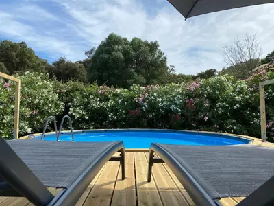 a swimming pool with a table and an umbrella at Villa Dominique Porto-Vecchio proche des plages in Porto-Vecchio